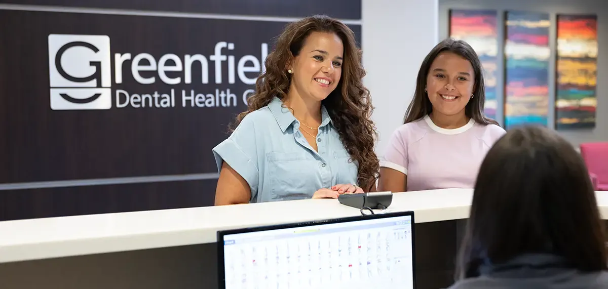 Receptionist greeting patients at Greenfield Dentistry
