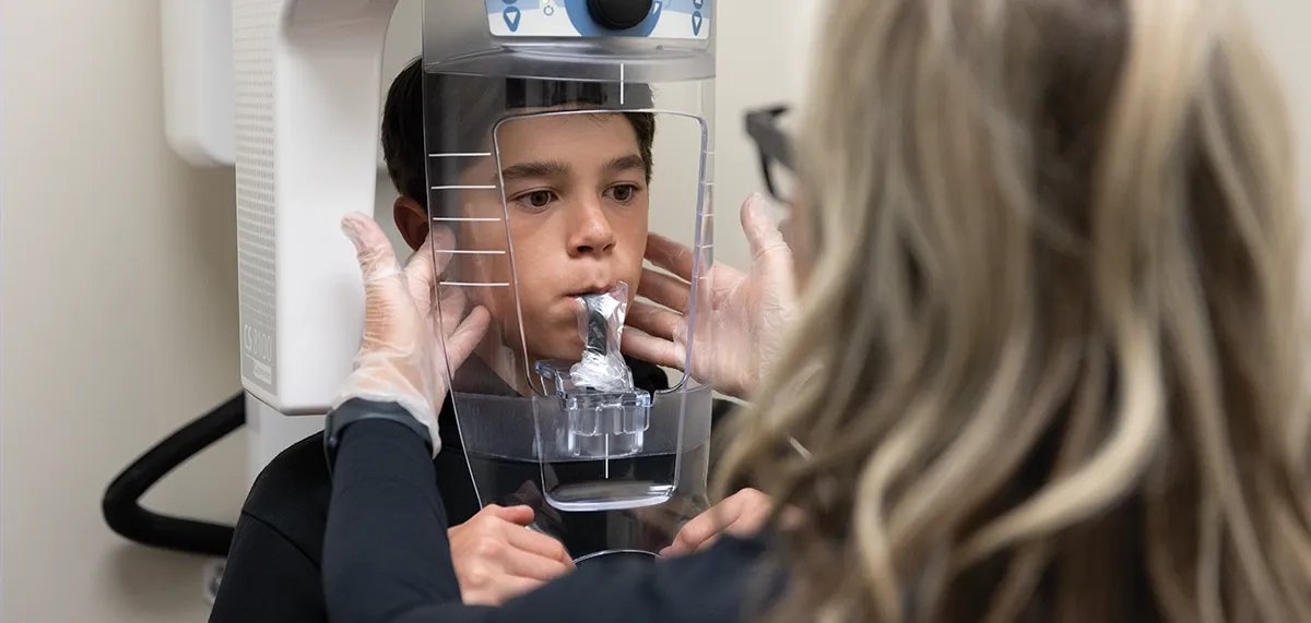 Performing dental x-ray on patient